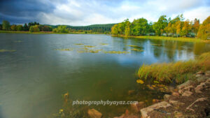 Autumn Lakeside with Cabins and Lily Pads – Fine Art Nature Photography  Photography by Ayaz